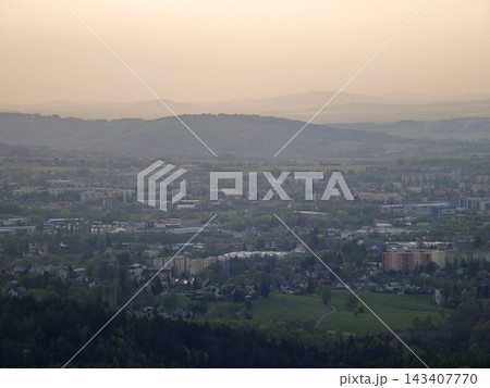 Urban landscape under evening haze. Overview of sprawling metropolis and surrounding green areas 143407770