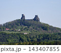Majestic ancient castle wreckage crowns hilltop overlooking forests and charming village below 143407855