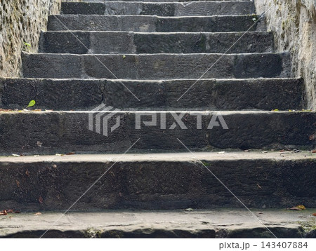 Weathered outdoor stone staircase with mossy walls and dim shade beneath historic stone enclosure, with stone, stair, staircase, outdoor detail, showing step, moss, wall, stonework context Weathered outdoor stone staircase with mossy walls and dim shade beneath historic stone enclosure, with stone, stair, staircase, outdoor detail, showing step, moss, wall, stonework context 143407884