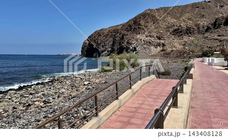 A Scenic Coastal Pathway Right by the Vast Sea Featuring a Beautiful Rocky Shoreline A Scenic Coastal Pathway Right by the Vast Sea Featuring a Beautiful Rocky Shoreline 143408128