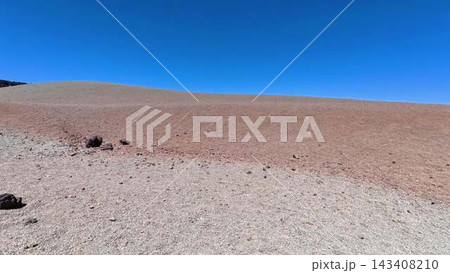 A Barren and Desolate Landscape Featuring Rocks Set Against a Clear and Bright Blue Sky 143408210
