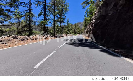 The beautiful scenic mountain road is surrounded by lush and vibrant pine trees all around The beautiful scenic mountain road is surrounded by lush and vibrant pine trees all around 143408348