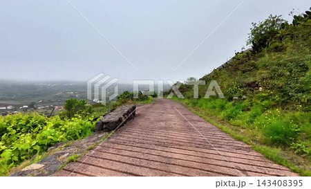A Beautiful, Scenic Pathway That Meanders Gently Through Lush, Green Hills on a Misty, Lovely Day A Beautiful, Scenic Pathway That Meanders Gently Through Lush, Green Hills on a Misty, Lovely Day 143408395