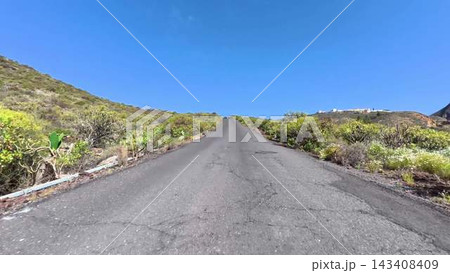 Enjoying a Scenic Road That Is Surrounded by Lush Greenery with a Beautiful Clear Blue Sky Enjoying a Scenic Road That Is Surrounded by Lush Greenery with a Beautiful Clear Blue Sky 143408409