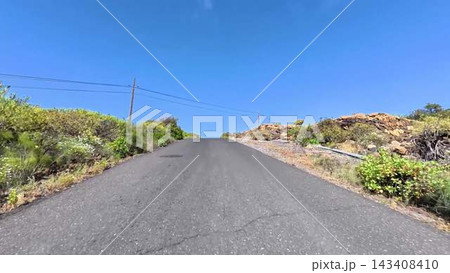 A scenic uphill road beautifully stretches ahead, framed by a clear blue sky and vibrant greenery A scenic uphill road beautifully stretches ahead, framed by a clear blue sky and vibrant greenery 143408410