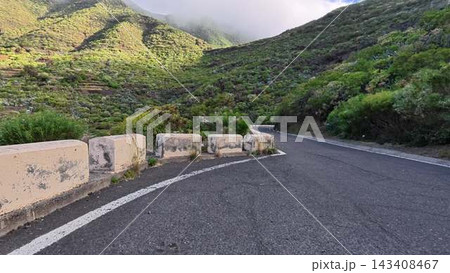 A Beautiful Curved Mountain Road that is Surrounded by Lush Greenery and Natures Wonders A Beautiful Curved Mountain Road that is Surrounded by Lush Greenery and Natures Wonders 143408467