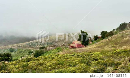 A breathtaking scenic mountain landscape filled with mist and charming rustic buildings A breathtaking scenic mountain landscape filled with mist and charming rustic buildings 143408533