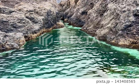 The Serene Cove, a beautiful spot, is surrounded by rocky shores and offers tranquility The Serene Cove, a beautiful spot, is surrounded by rocky shores and offers tranquility 143408565