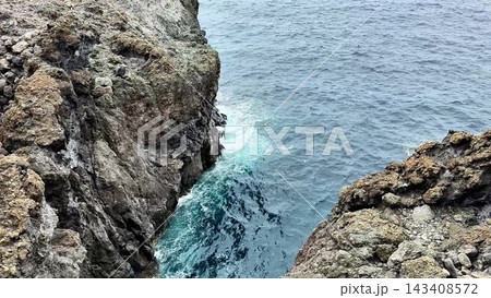 Stunning Coastal Rock Formation Majestically Towering Above the Turquoise Sea Below Stunning Coastal Rock Formation Majestically Towering Above the Turquoise Sea Below 143408572
