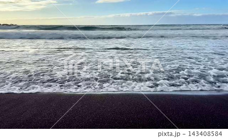 Waves Roll and Crash on a Stunning Black Sand Beach at Dusk Near the Beautiful Horizon Waves Roll and Crash on a Stunning Black Sand Beach at Dusk Near the Beautiful Horizon 143408584