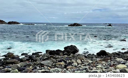 The Serene Ocean Waves Are Gently Splashing on the Rocky Shoreline, Creating a Peaceful Atmosphere The Serene Ocean Waves Are Gently Splashing on the Rocky Shoreline, Creating a Peaceful Atmosphere 143408623