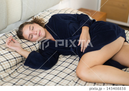 Young woman sleeping on bed in bedroom Young woman sleeping on bed in bedroom 143408838