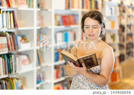 In bookstore woman choose book In bookstore woman choose book 143408839