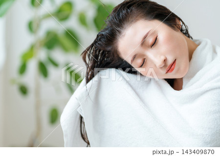 濡れた髪をタオルドライする女性。入浴後のヘアケアとリラックスタイム 143409870