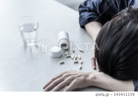 薬を飲んで倒れる女性 143411159