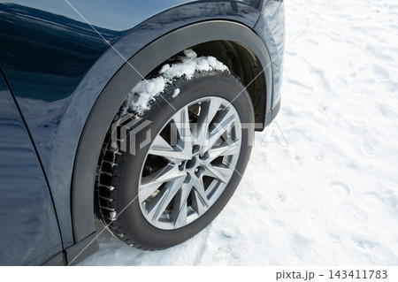 Vehicle stands still on icy terrain showcasing winter tire capabilities Vehicle stands still on icy terrain showcasing winter tire capabilities 143411783
