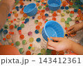 カラフルなスーパーボールをすくう子どもの手 143412361