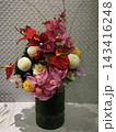 竹筒の花器に生けられた華やかなお正月の和風フラワーアレンジメント 143416248