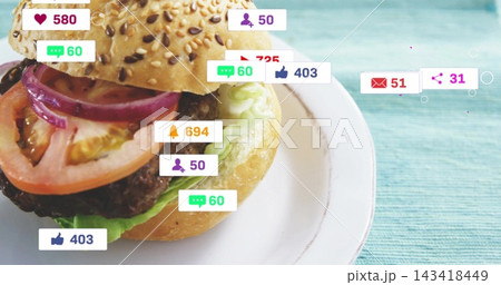 Displaying sesame bun hamburger sitting on white plate over turquoise tabletop, with social badges 143418449
