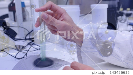 Holding right hand wearing lab coat sleeve placing cuvette above vortex mixer on lab bench, overlay Holding right hand wearing lab coat sleeve placing cuvette above vortex mixer on lab bench, overlay 143426633