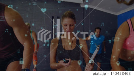 Leading female coach in tank top timing cardio in studio, holding stopwatch, clipboard, AR overlay Leading female coach in tank top timing cardio in studio, holding stopwatch, clipboard, AR overlay 143428468