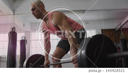 Lifting bald man gripping loaded barbell at gym in coral tank and dark shorts, circular overlay 143428521