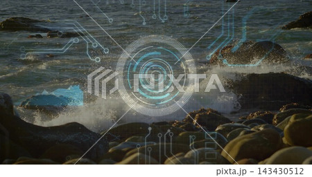 Glowing concentric HUD target hovering over front boulders at coast, with breaking waves 143430512