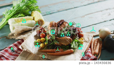 Showing roasted whole chicken on cutting board on blue tabletop with vegetables and teal eco icons Showing roasted whole chicken on cutting board on blue tabletop with vegetables and teal eco icons 143430836