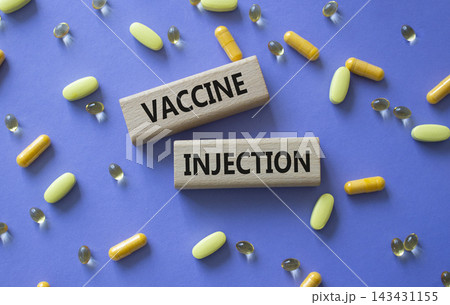 Vaccine Injection symbol. Concept word Vaccine Injection on wooden blocks. Beautiful purple background with pills. Medicine and Vaccine Injection. Copy space Vaccine Injection symbol. Concept word Vaccine Injection on wooden blocks. Beautiful purple background with pills. Medicine and Vaccine Injection. Copy space 143431155