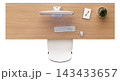 A desktop setup with a monitor, keyboard, mouse, notepad, and plant on a wooden desk. The layout is simple and clear, arranged neatly for work 143433657