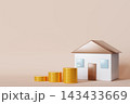 A house model stands next to stacks of gold coins. This setup represents financial concepts and savings. The background is plain with ample copy 143433669
