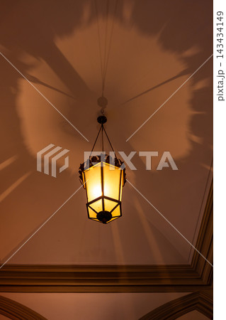 Warm Vintage Hanging Lantern Casting Dramatic Shadows On Ornate Ceiling In Historic Interior 143434149
