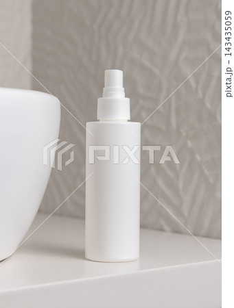 White blank cosmetic spray bottle mockup near white towel in beige bathroom, unbranded packaging White blank cosmetic spray bottle mockup near white towel in beige bathroom, unbranded packaging 143435059