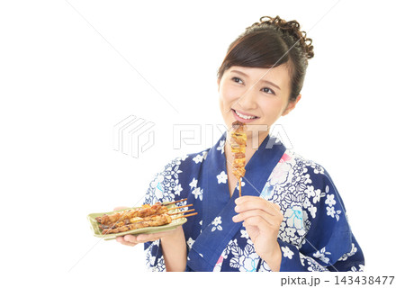 やきとりを持つ浴衣姿の女性 143438477