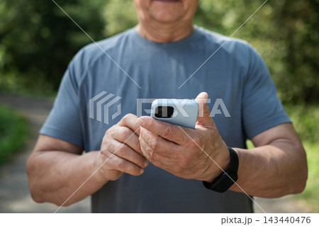 Mature man using smartphone after outdoor workout 143440476