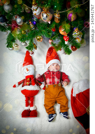 Baby and Snowman Toy Celebrate Christmas Under the Decorated Tree With Festive Ornaments Baby and Snowman Toy Celebrate Christmas Under the Decorated Tree With Festive Ornaments 143441767