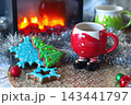 Winter holiday scene with festive decorations, cookies, and warm beverage in a colorful mug 143441797