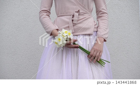 Cute woman holds a vibrant bouquet of yellow daffodil Cute woman holds a vibrant bouquet of yellow daffodil 143441868