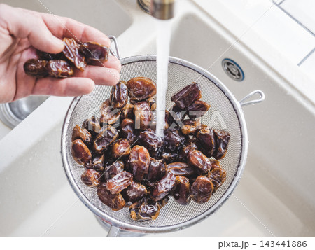 Male hands wash dried dates 143441886