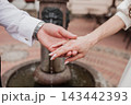 Close up of bride and groom holding hands showing engagement ring. 143442393
