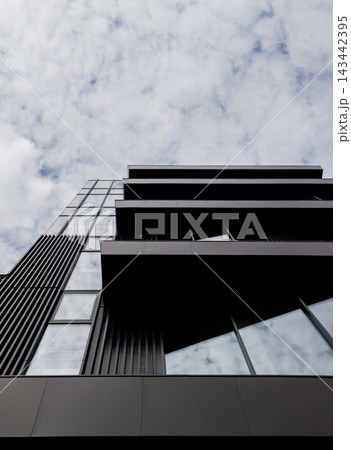 Low angle view of modern black building facade with glass balconies. Low angle view of modern black building facade with glass balconies. 143442395