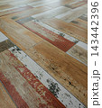 Distressed wood look ceramic floor tiles in herringbone pattern 143442396