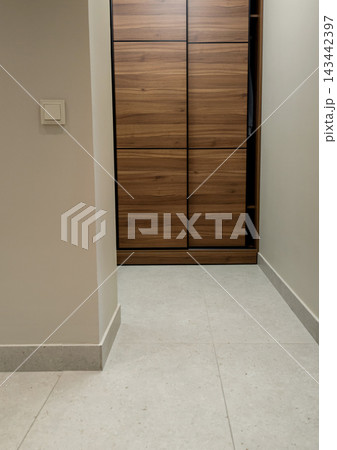 Modern wooden sliding door wardrobe in apartment hallway. Modern wooden sliding door wardrobe in apartment hallway. 143442397