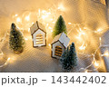 Cozy Christmas village with wooden miniature houses and fairy lights. 143442402