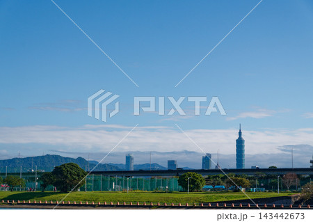 Taipei 101 skyline above riverside park and elevated expressway under blue sky Taipei 101 skyline above riverside park and elevated expressway under blue sky 143442673