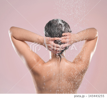 Woman, hair and back or washing in studio, pink background and cleansing with shampoo or model under water. Grooming, hygiene and female person wet for self care, showering foam and wellness routine 143443255
