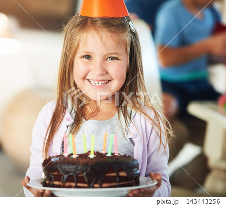Portrait, kid and girl in house with birthday cake, party hat or sweet treat for childhood development. Special day, milestone celebration and child in home with chocolate dessert, candles or growth. 143443256