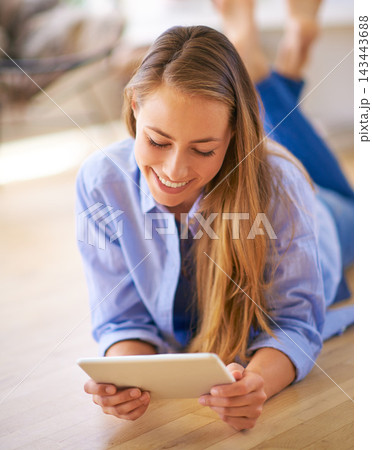 Happy, woman and tablet laying on floor for streaming, social media post or connection in home. Female person, smile and tech relax for online research, internet news and reading blog in house Happy, woman and tablet laying on floor for streaming, social media post or connection in home. Female person, smile and tech relax for online research, internet news and reading blog in house 143443688