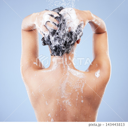 Girl, back and shampoo in studio for shower for hygiene, hair care and wellness for scalp or cleanliness with soap. Woman, isolated and blue background with water splash, refreshing and grooming. Girl, back and shampoo in studio for shower for hygiene, hair care and wellness for scalp or cleanliness with soap. Woman, isolated and blue background with water splash, refreshing and grooming. 143443813