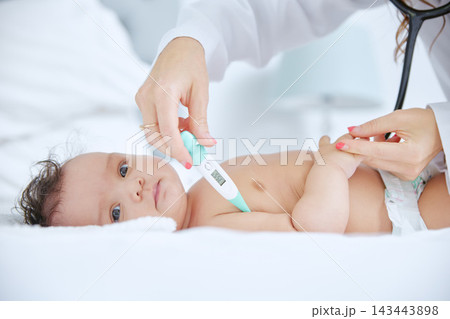 Doctor, hands and baby with thermometer for checkup, exam or test in healthcare on bed at home. Woman or pediatrician checking infant or young newborn for medical care or fever in bedroom at house Doctor, hands and baby with thermometer for checkup, exam or test in healthcare on bed at home. Woman or pediatrician checking infant or young newborn for medical care or fever in bedroom at house 143443898